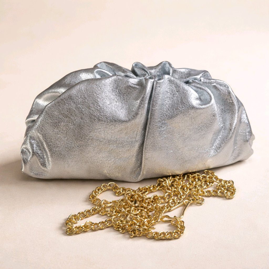 Bolso de mano modelo Capri en piel metalizada color plata con diseño fruncido y cadena dorada de Muzetto