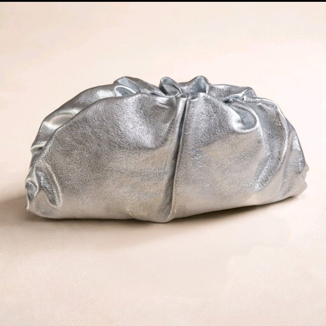 Bolso de mano modelo Capri en piel metalizada color plata con diseño fruncido y cadena dorada de Muzetto