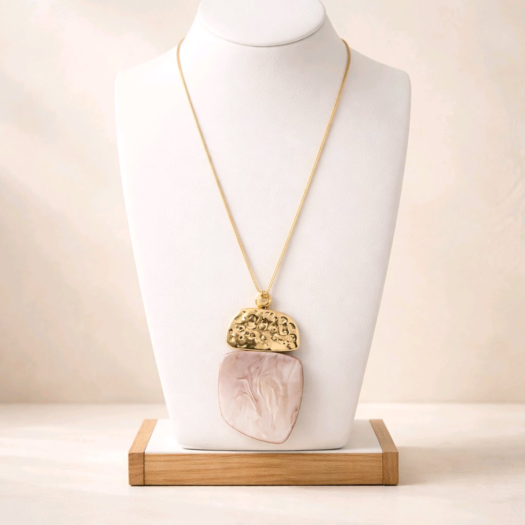 Primer plano de mujer con el collar Máxima rosa arena, colgante de resina y metal dorado sobre cordón de seda.