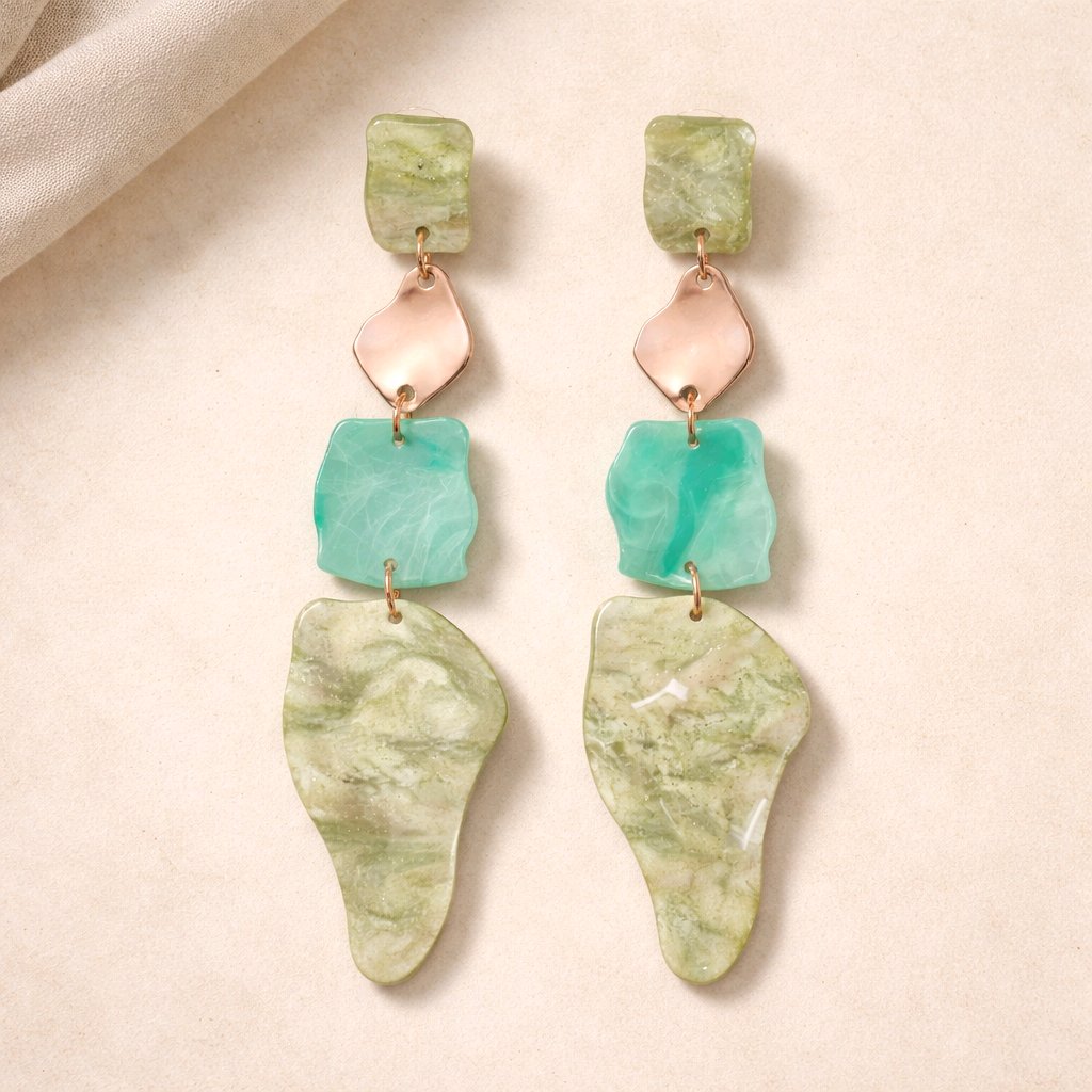 Pendientes largos de diseño orgánico con piezas de resina marmoleada en verde jade y metal dorado, estilo vanguardista Muzetto