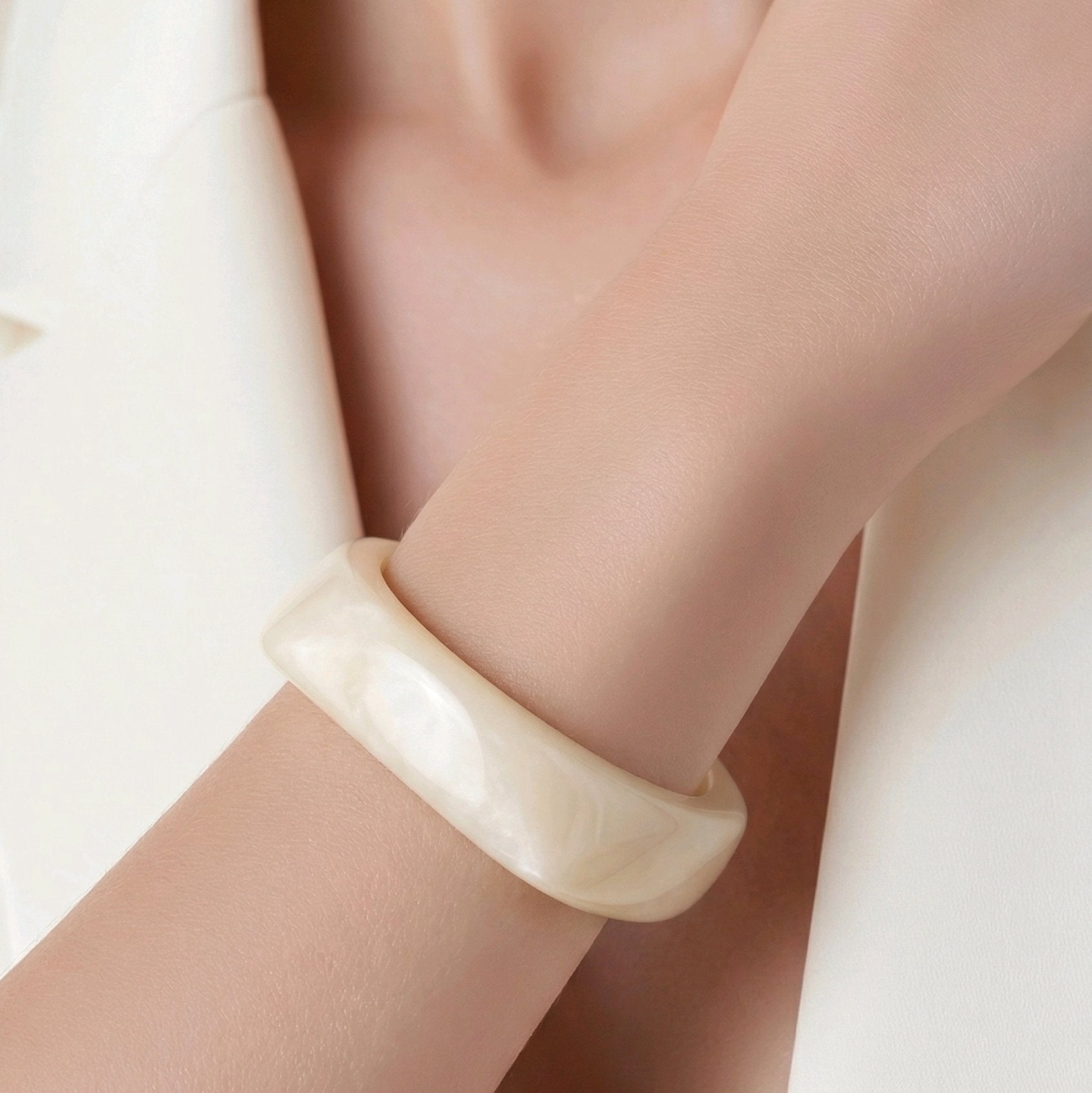 Pulsera de resina marmoleada color marfil con diseño orgánico de inspiración escultórica de Muzetto